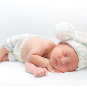 sleeping baby in knit cap and pants